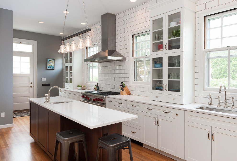 Inspiration for a large transitional galley medium tone wood floor kitchen pantry remodel in Portland with a single-bowl sink, shaker cabinets, white cabinets, quartz countertops, white backsplash, subway tile backsplash, stainless steel appliances and an island