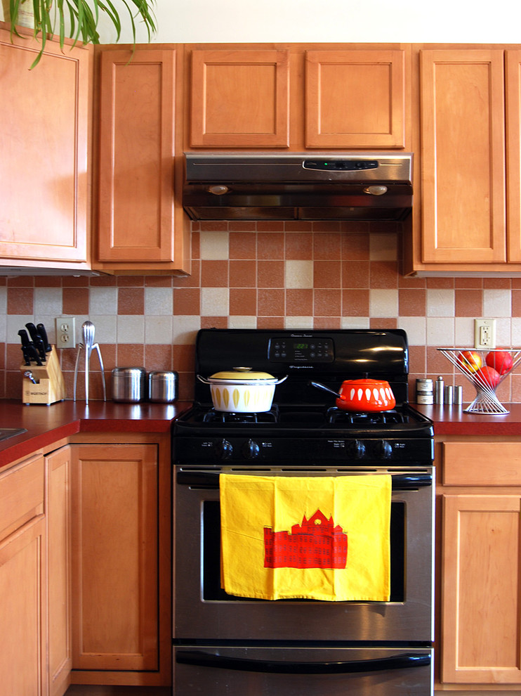 Exemple d'une cuisine chic en bois brun avec un placard avec porte à panneau encastré, une crédence beige et un électroménager en acier inoxydable.