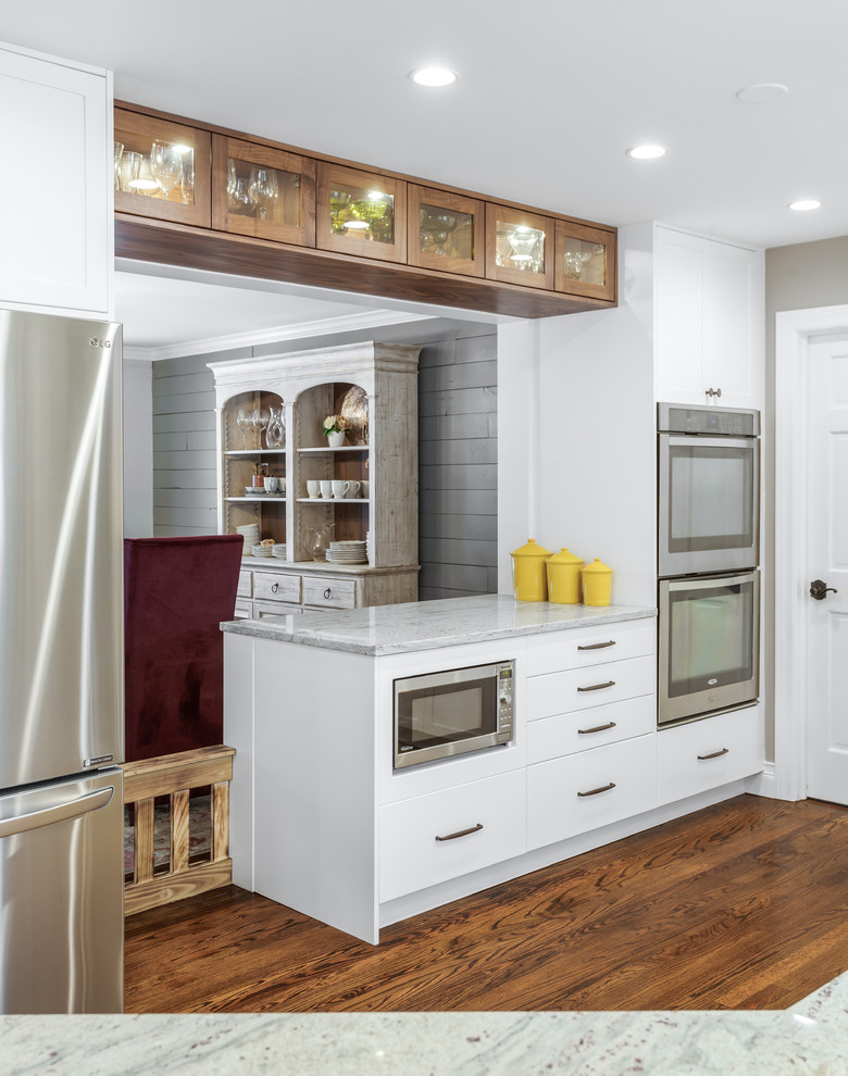 Eat-in kitchen - mid-sized contemporary l-shaped dark wood floor and brown floor eat-in kitchen idea in Chicago with an undermount sink, shaker cabinets, white cabinets, granite countertops, white backsplash, stainless steel appliances, an island and white countertops