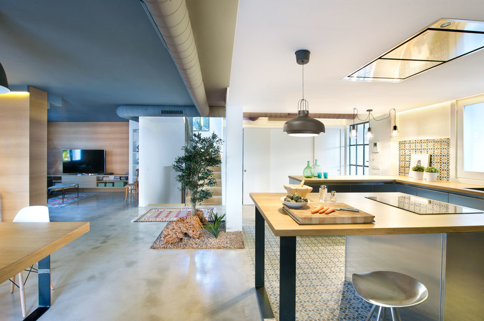 Inspiration for a large industrial u-shaped eat-in kitchen remodel in Madrid with flat-panel cabinets, stainless steel cabinets, wood countertops, multicolored backsplash, ceramic backsplash, stainless steel appliances and an island