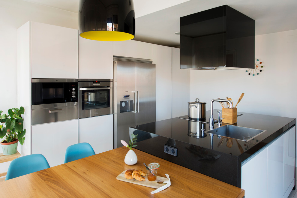 Zweizeilige, Mittelgroße Moderne Wohnküche mit Waschbecken, flächenbündigen Schrankfronten, Küchengeräten aus Edelstahl, Mineralwerkstoff-Arbeitsplatte und Kücheninsel in Madrid