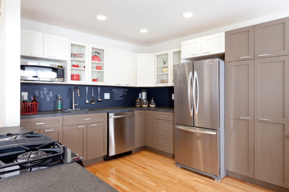 Immagine di una cucina ad U design con lavello sottopiano, ante in stile shaker, paraspruzzi nero e elettrodomestici in acciaio inossidabile