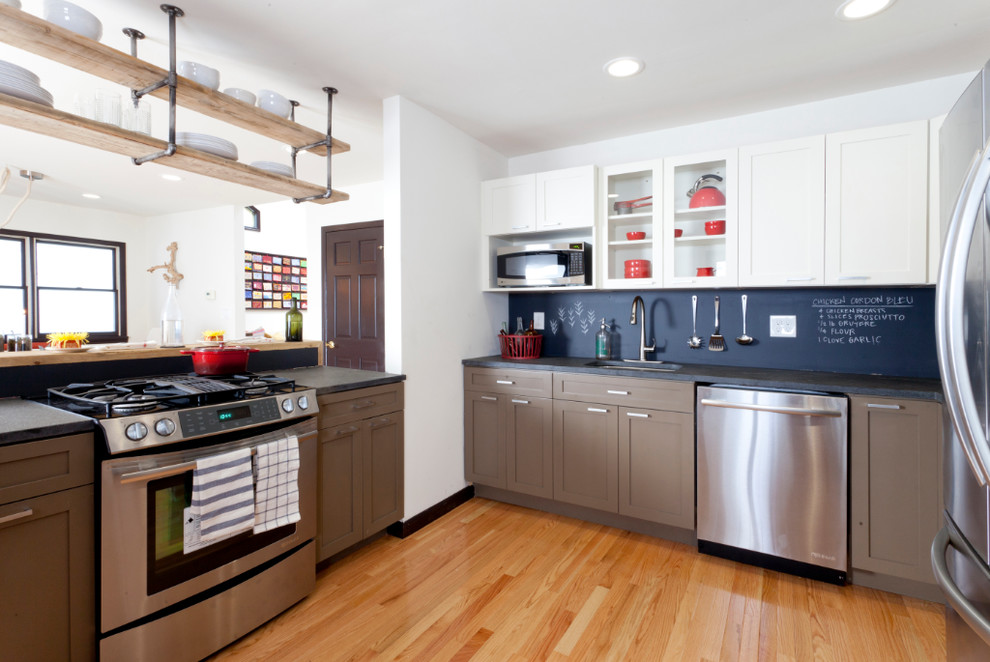 Inspiration for a contemporary u-shaped kitchen remodel in New York with an undermount sink, shaker cabinets, black backsplash and stainless steel appliances