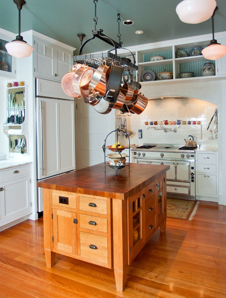 シアトルにあるトラディショナルスタイルのおしゃれなキッチン (木材カウンター、オープンシェルフ、白いキャビネット、パネルと同色の調理設備) の写真