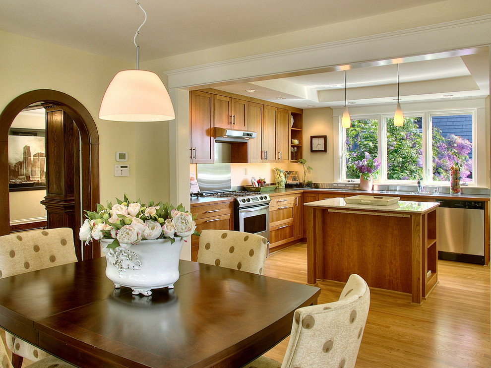 Пример оригинального дизайна: кухня в современном стиле с обеденным столом, фасадами в стиле шейкер и светлыми деревянными фасадами