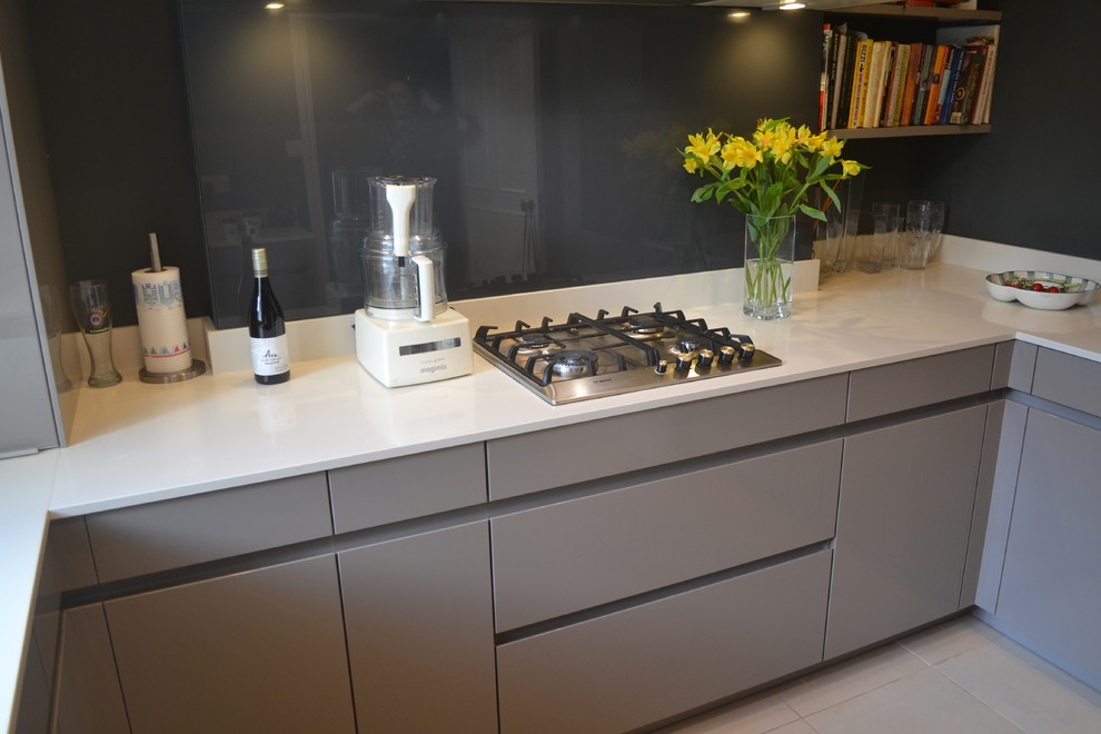Esempio di una piccola cucina ad U design chiusa con lavello sottopiano, ante lisce, ante grigie, top in laminato, paraspruzzi grigio, paraspruzzi con lastra di vetro e elettrodomestici neri