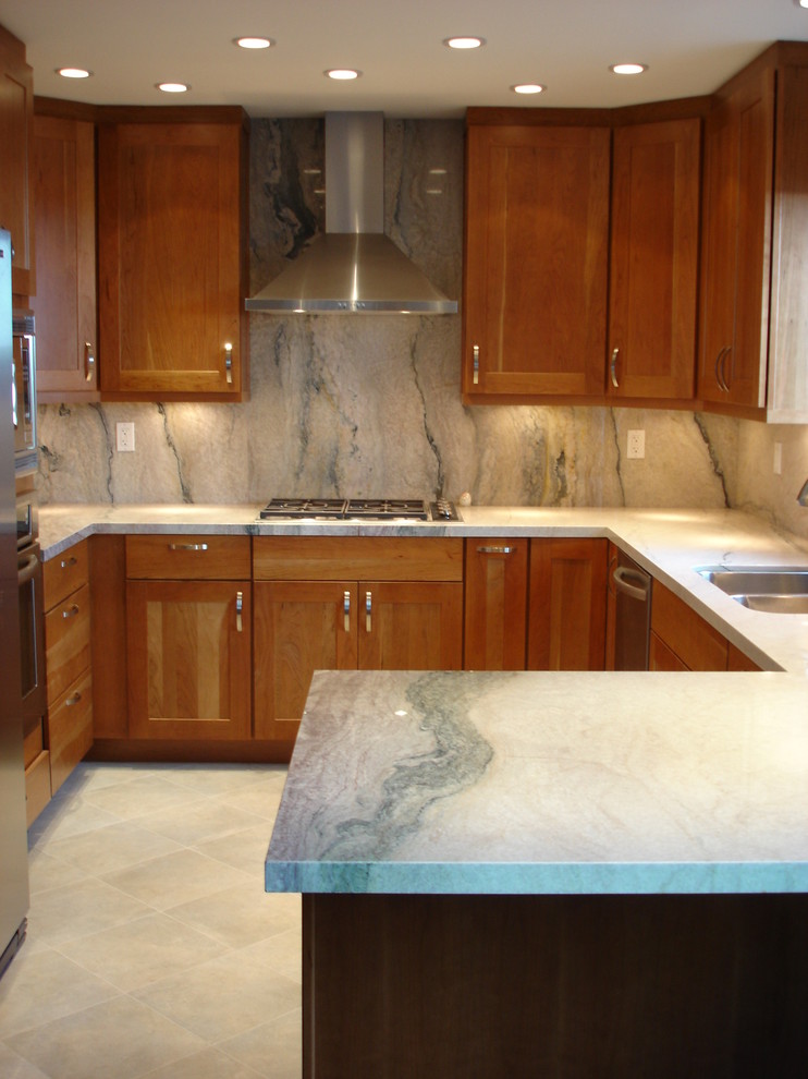 Mid-sized elegant u-shaped travertine floor enclosed kitchen photo in Other with a double-bowl sink, shaker cabinets, medium tone wood cabinets, marble countertops, gray backsplash, stone slab backsplash, stainless steel appliances and a peninsula