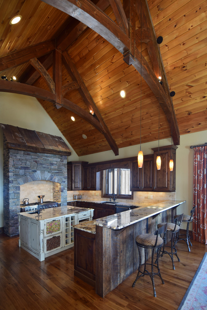 Inredning av ett rustikt stort kök, med en undermonterad diskho, luckor med upphöjd panel, skåp i slitet trä, granitbänkskiva, beige stänkskydd, stänkskydd i stenkakel, rostfria vitvaror, mellanmörkt trägolv och en köksö