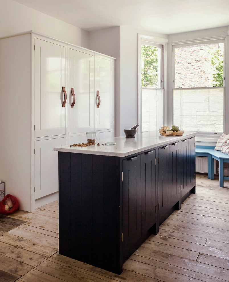 Stilmix Küche mit profilierten Schrankfronten und braunem Holzboden in London