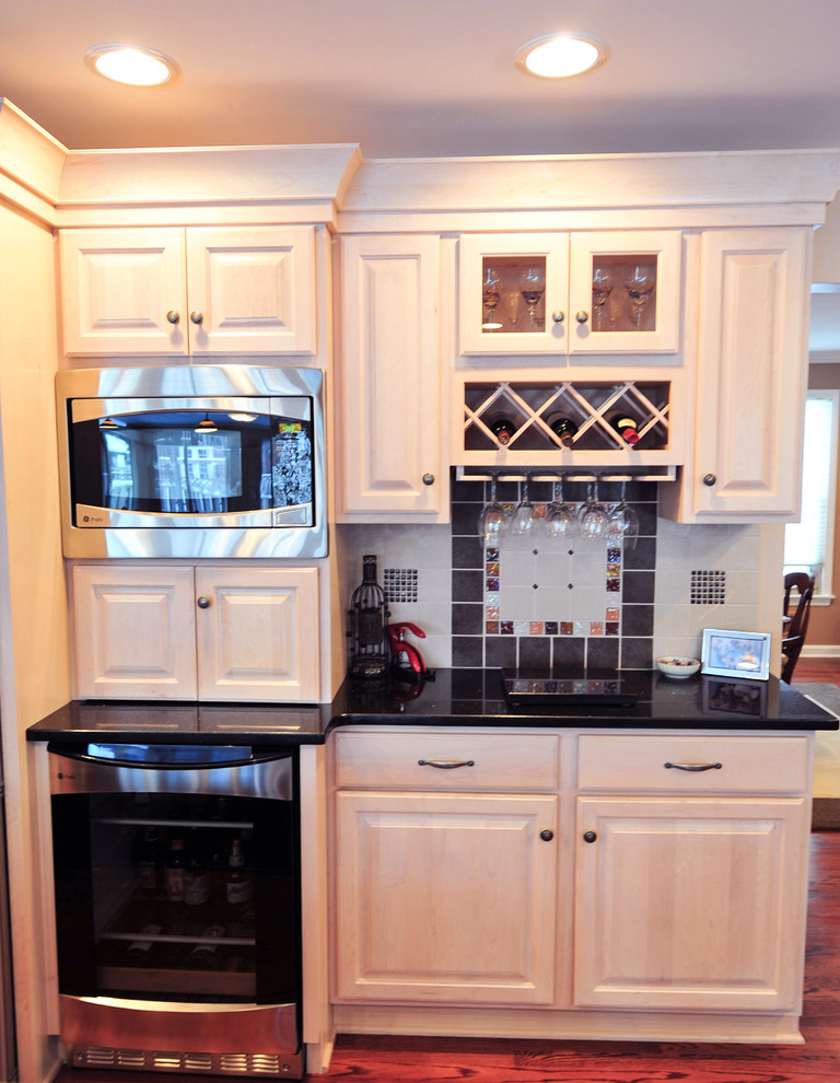 Immagine di un grande cucina con isola centrale classico con ante in legno chiaro, top in granito e elettrodomestici in acciaio inossidabile