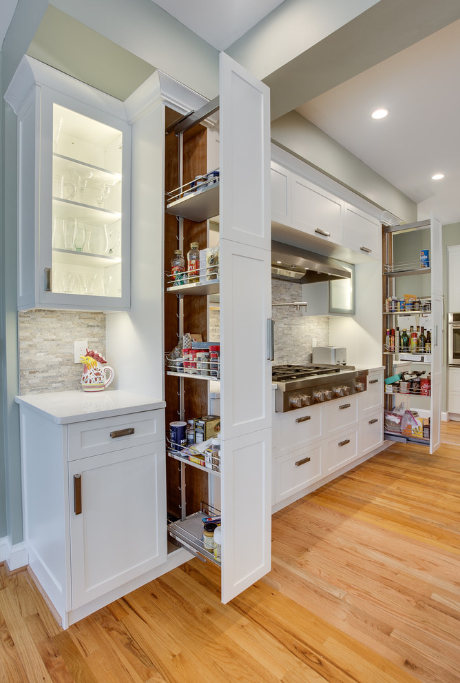 Inspiration for a large transitional l-shaped light wood floor eat-in kitchen remodel in DC Metro with a farmhouse sink, recessed-panel cabinets, white cabinets, soapstone countertops, stainless steel appliances and two islands