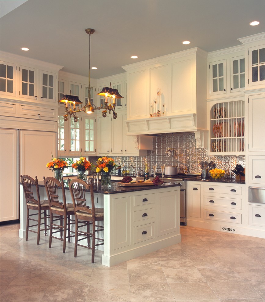 Enclosed kitchen - large traditional u-shaped travertine floor and beige floor enclosed kitchen idea in Charleston with shaker cabinets, white cabinets, granite countertops, gray backsplash, glass tile backsplash, paneled appliances, an island, an undermount sink and black countertops