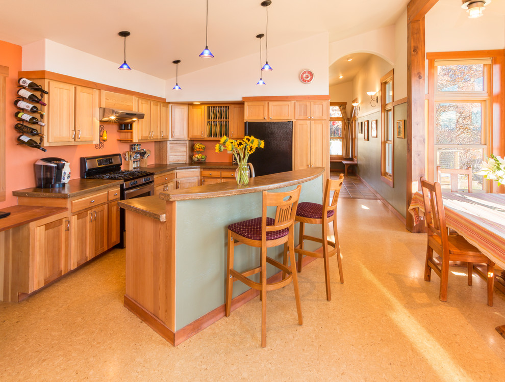 Cette image montre une cuisine ouverte design en L et bois brun avec un placard à porte shaker et un électroménager noir.