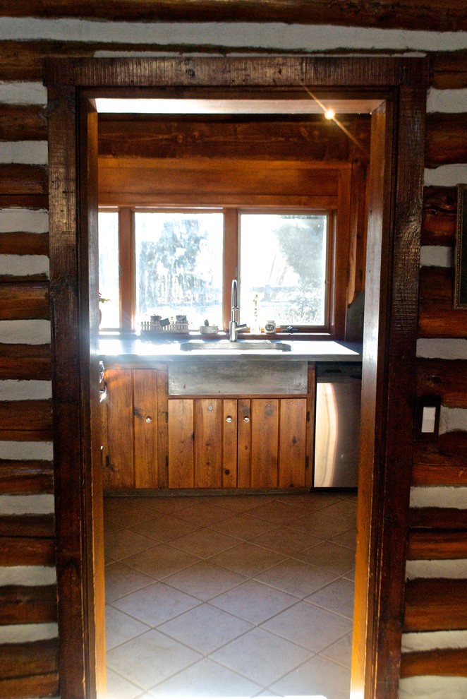 Idée de décoration pour une cuisine chalet en U et bois brun de taille moyenne avec un plan de travail en béton, une crédence grise et aucun îlot.