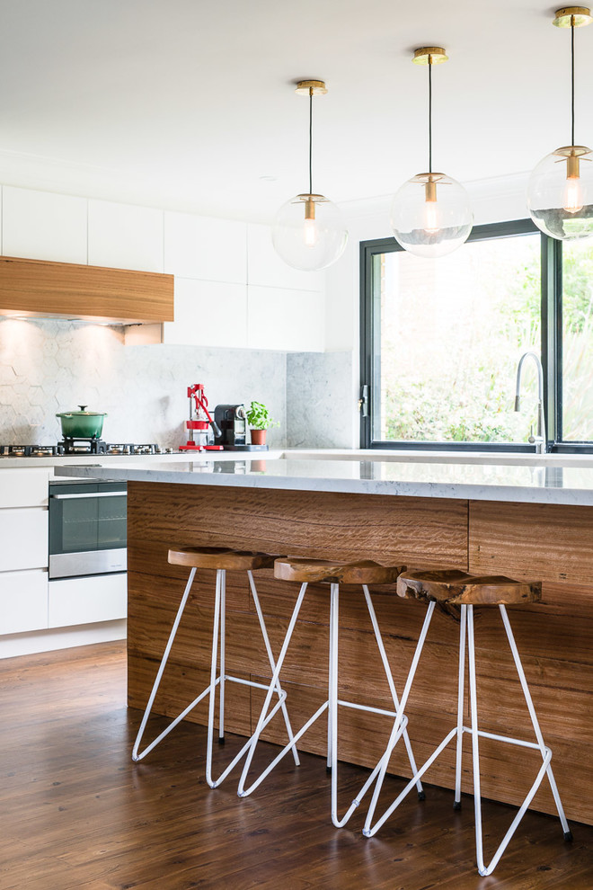 Esempio di un cucina con isola centrale contemporaneo con ante lisce, ante bianche, paraspruzzi grigio, pavimento in legno massello medio, pavimento marrone e top grigio