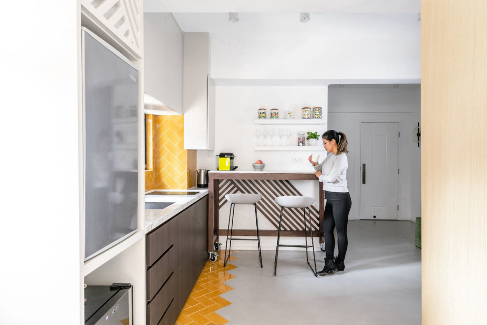 Inredning av ett asiatiskt litet vit linjärt vitt kök med öppen planlösning, med en undermonterad diskho, släta luckor, skåp i mörkt trä, marmorbänkskiva, gult stänkskydd, stänkskydd i keramik, rostfria vitvaror, klinkergolv i keramik, en halv köksö och gult golv