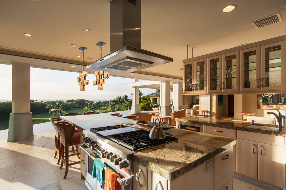 Inspiration for a large tropical u-shaped travertine floor and beige floor open concept kitchen remodel in Hawaii with glass-front cabinets, brown cabinets, limestone countertops, beige backsplash and an island