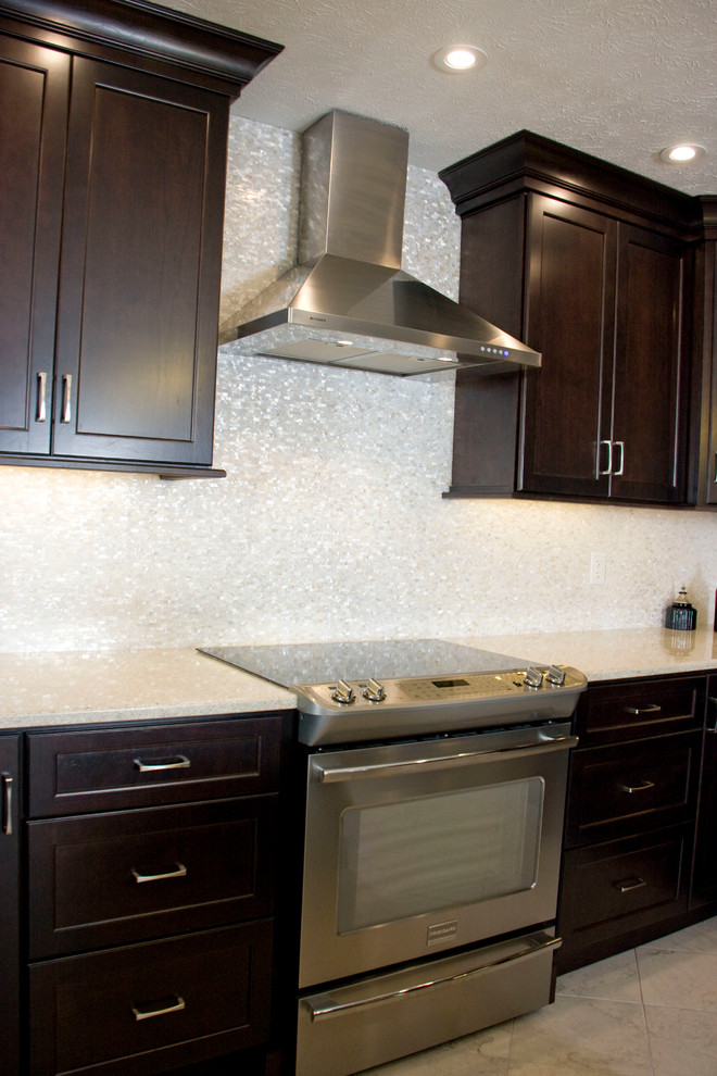 Medium sized modern kitchen in Other with dark wood cabinets, white splashback and stainless steel appliances.