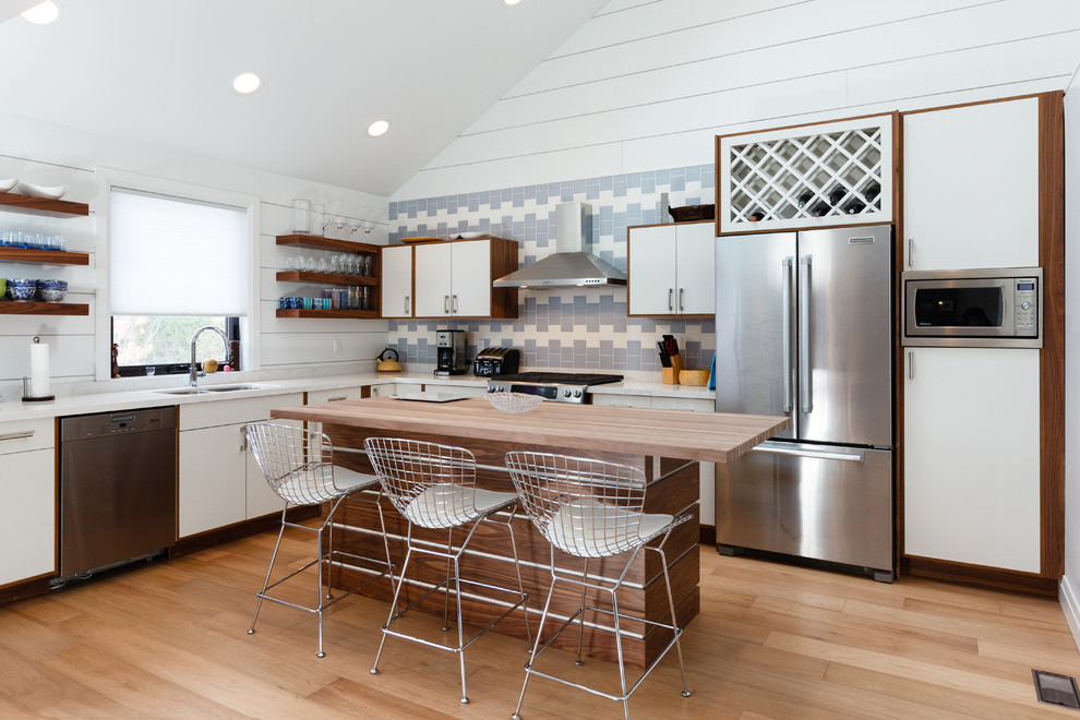 Inspiration for a small transitional light wood floor eat-in kitchen remodel with a double-bowl sink, blue backsplash, stainless steel appliances and an island
