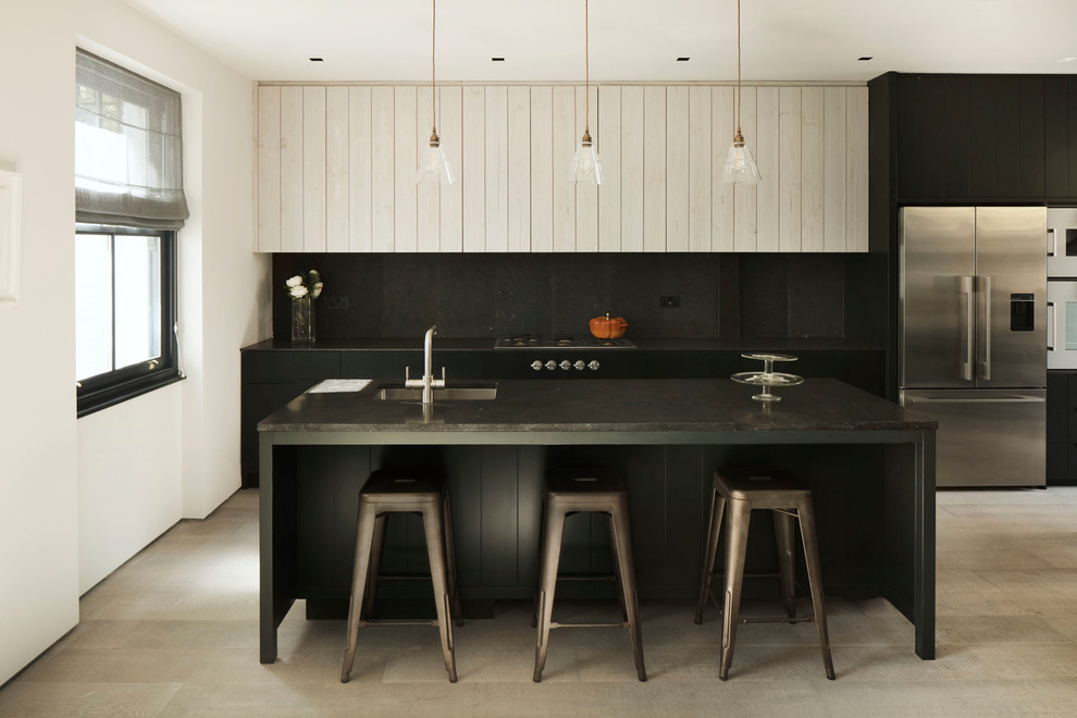 Immagine di una cucina contemporanea chiusa e di medie dimensioni con ante lisce, paraspruzzi nero, elettrodomestici in acciaio inossidabile, parquet chiaro, pavimento beige e ante nere