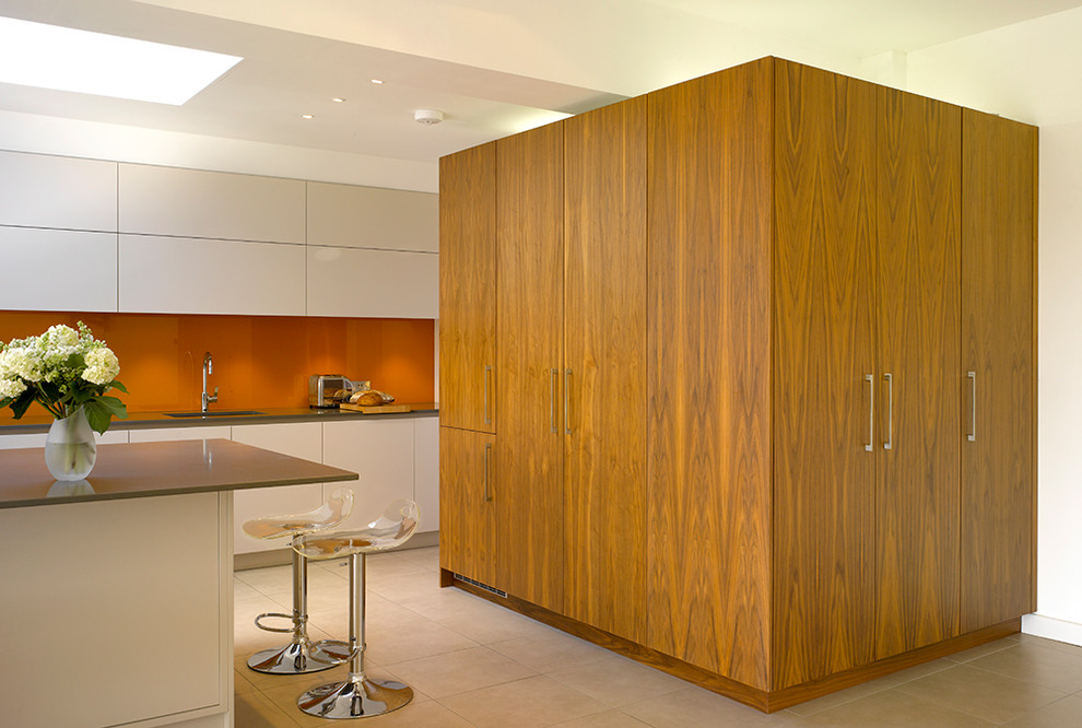 Exempel på ett stort modernt beige linjärt beige kök med öppen planlösning, med släta luckor, vita skåp, bänkskiva i kvartsit, orange stänkskydd, glaspanel som stänkskydd, integrerade vitvaror, klinkergolv i keramik, en köksö och beiget golv