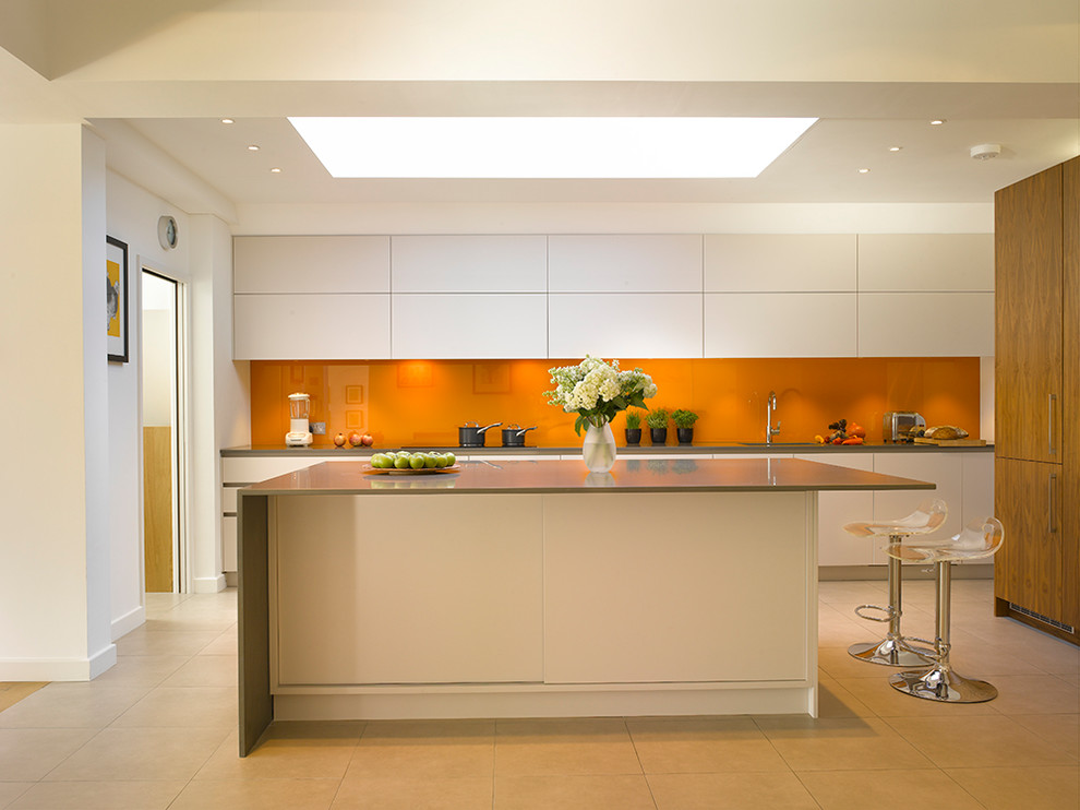 Photo of a large contemporary kitchen in London with flat-panel cabinets, white cabinets, quartz worktops, orange splashback, glass sheet splashback, ceramic flooring, an island, beige floors and grey worktops.