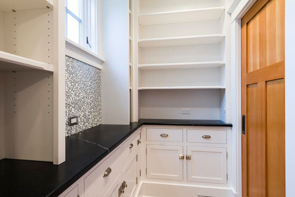 This is an example of a large classic single-wall kitchen pantry in Philadelphia with a belfast sink, white cabinets, soapstone worktops, stainless steel appliances, ceramic flooring and an island.