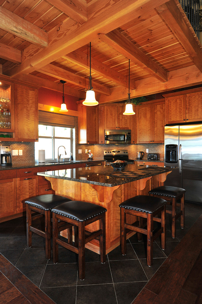 Cette image montre une cuisine ouverte traditionnelle en L et bois brun avec un évier encastré, un placard à porte shaker, un plan de travail en granite, une crédence marron et un électroménager en acier inoxydable.