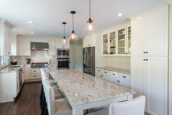 Example of a large arts and crafts u-shaped dark wood floor eat-in kitchen design in Nashville with shaker cabinets, white cabinets, granite countertops, white backsplash, ceramic backsplash, stainless steel appliances and an island