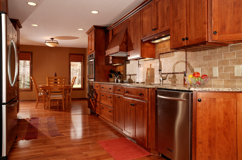 Bild på ett mellanstort vintage kök, med en undermonterad diskho, skåp i shakerstil, skåp i mellenmörkt trä, granitbänkskiva, beige stänkskydd, stänkskydd i stenkakel, rostfria vitvaror och mellanmörkt trägolv