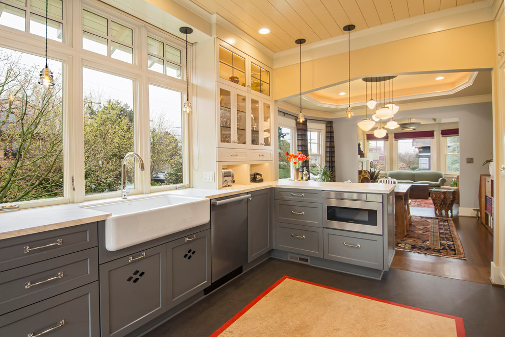 This is an example of a large farmhouse u-shaped kitchen/diner in Seattle with a belfast sink, shaker cabinets, grey cabinets, composite countertops, multi-coloured splashback, porcelain splashback, coloured appliances, lino flooring, a breakfast bar and multi-coloured floors.