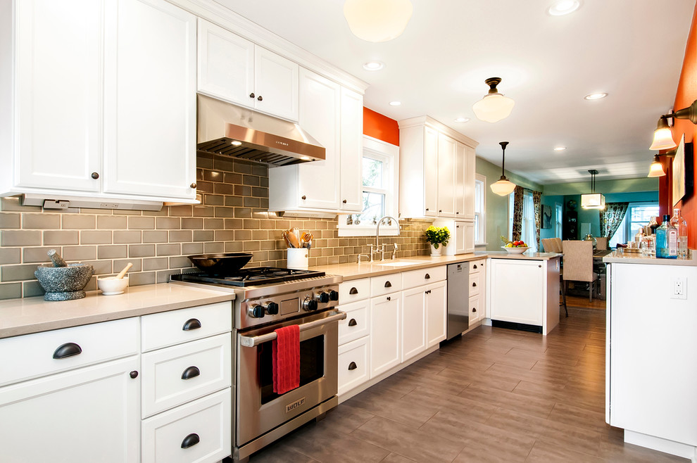 Large elegant single-wall eat-in kitchen photo in Seattle with an undermount sink, white cabinets, gray backsplash, ceramic backsplash, stainless steel appliances and a peninsula