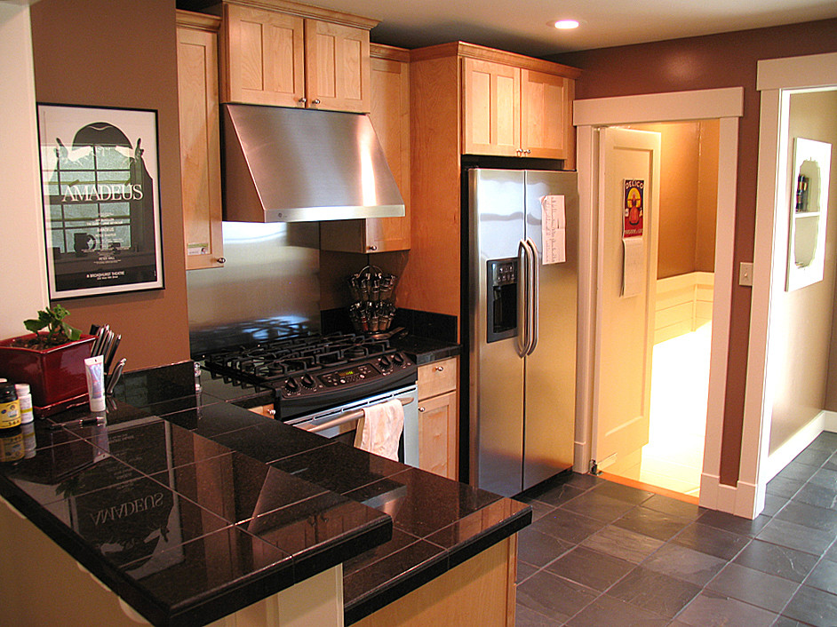 Idéer för ett litet amerikanskt svart kök, med skåp i shakerstil, skåp i mellenmörkt trä, rostfria vitvaror, skiffergolv, en halv köksö, grönt golv, en undermonterad diskho och granitbänkskiva