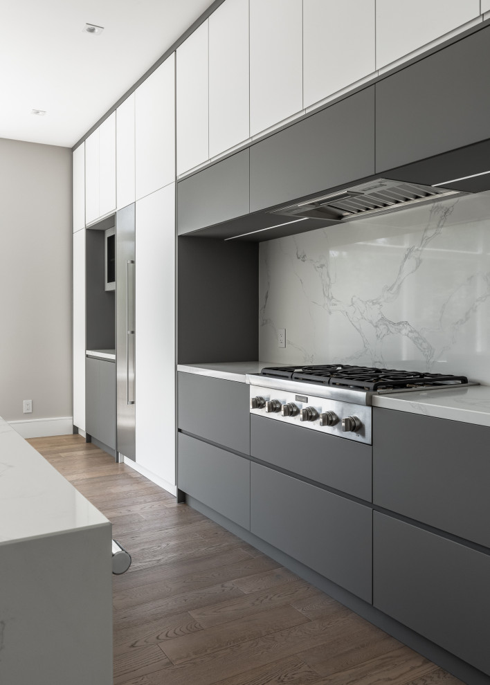 Immagine di una grande cucina minimalista con ante lisce, ante bianche e top in quarzite