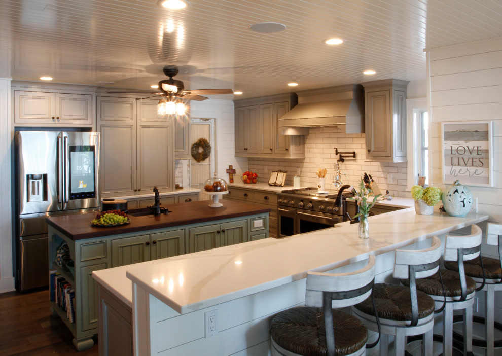 Exempel på ett lantligt vit vitt kök och matrum, med en rustik diskho, luckor med upphöjd panel, grå skåp, bänkskiva i kvartsit, vitt stänkskydd, stänkskydd i tunnelbanekakel, rostfria vitvaror, mörkt trägolv, flera köksöar och brunt golv