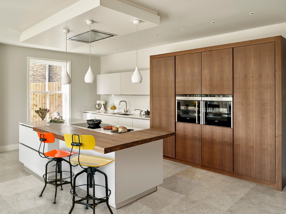 Einzeilige, Mittelgroße Moderne Wohnküche mit Doppelwaschbecken, weißen Schränken, Mineralwerkstoff-Arbeitsplatte, Elektrogeräten mit Frontblende und Kücheninsel in London