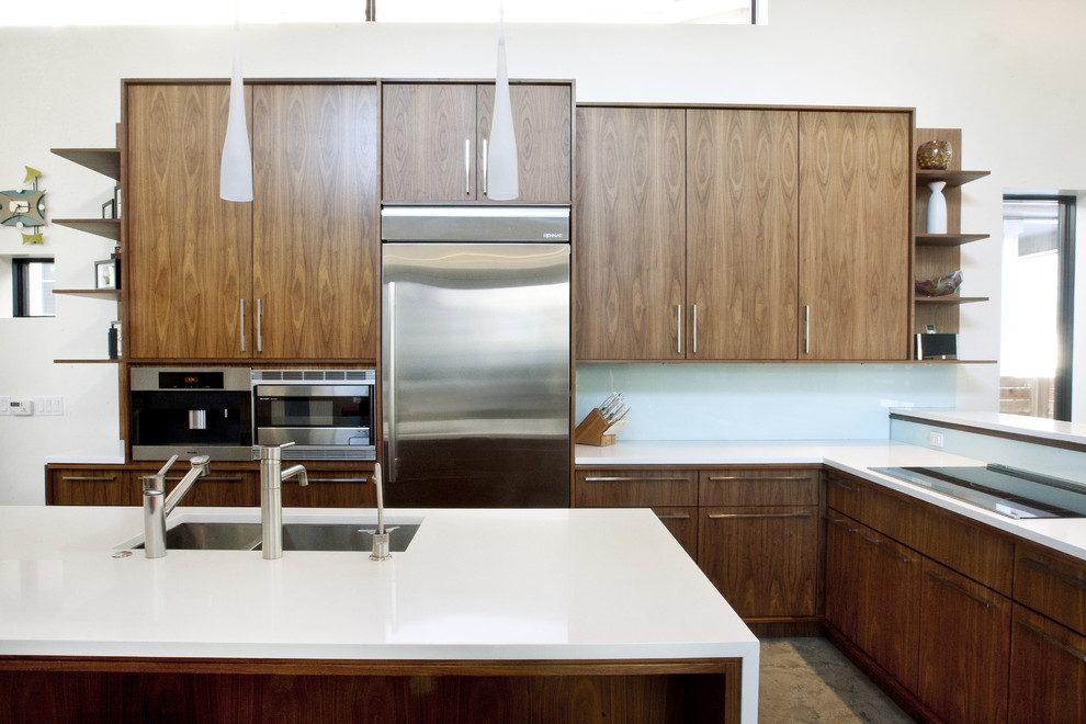 Moderne Küche mit Küchengeräten aus Edelstahl, flächenbündigen Schrankfronten, dunklen Holzschränken, Quarzwerkstein-Arbeitsplatte, Glasrückwand und Doppelwaschbecken in Denver