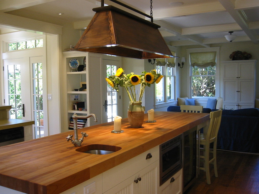Стильный дизайн: кухня в современном стиле с врезной мойкой, белыми фасадами и деревянной столешницей - последний тренд
