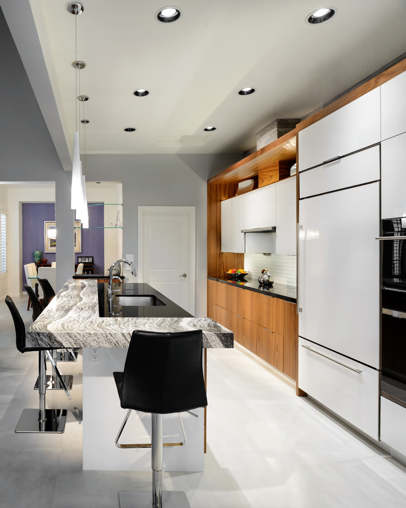 Пример оригинального дизайна: параллельная кухня-гостиная среднего размера в современном стиле с одинарной мойкой, плоскими фасадами, столешницей из кварцевого агломерата, фартуком из стеклянной плитки, техникой под мебельный фасад и островом