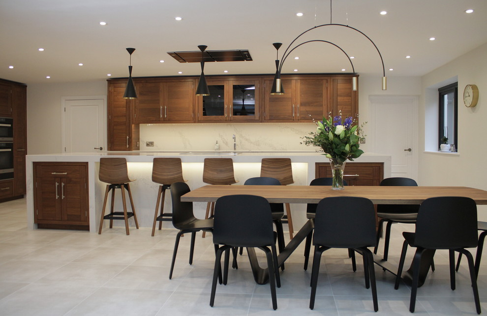 Design ideas for an expansive contemporary kitchen in Hertfordshire with a built-in sink, dark wood cabinets, quartz worktops, stainless steel appliances, porcelain flooring, an island and beige floors.