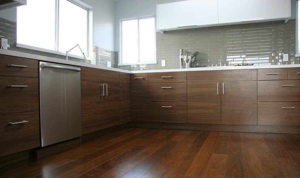 Example of a trendy u-shaped eat-in kitchen design in Los Angeles with shaker cabinets, dark wood cabinets, solid surface countertops and stainless steel appliances