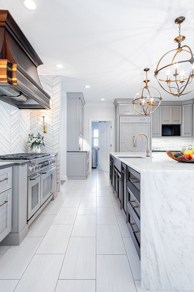 Example of a large minimalist u-shaped porcelain tile and gray floor kitchen design in Other with a farmhouse sink, gray cabinets, marble countertops, gray backsplash, marble backsplash, stainless steel appliances, an island and multicolored countertops
