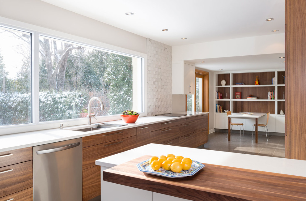 Exempel på ett mellanstort modernt kök, med en dubbel diskho, släta luckor, skåp i mellenmörkt trä, bänkskiva i kvarts, vitt stänkskydd, stänkskydd i stenkakel, rostfria vitvaror, klinkergolv i porslin och en köksö