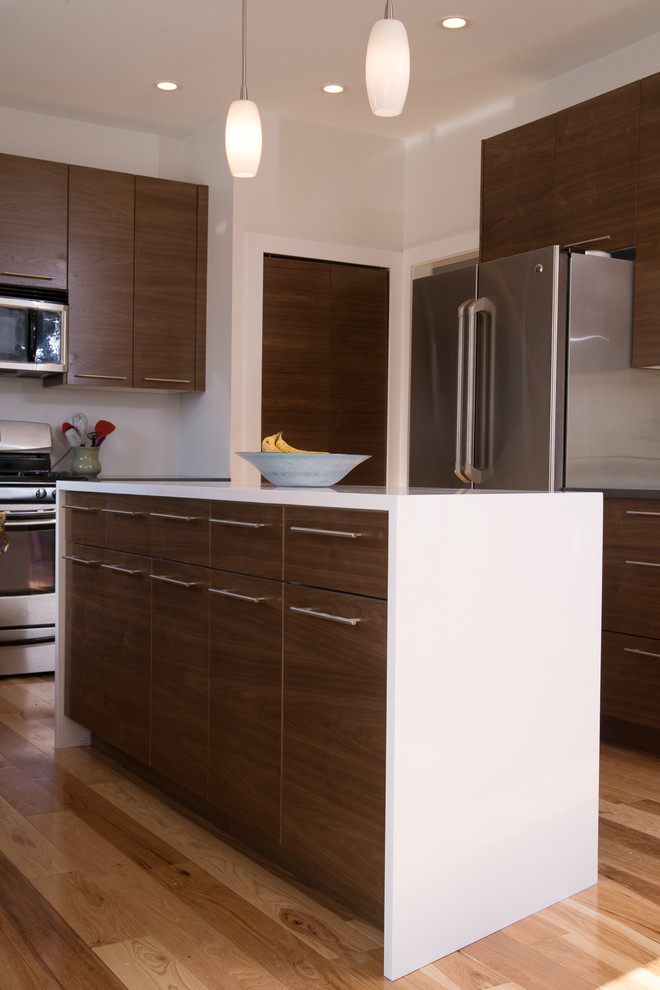 Ejemplo de cocina actual con armarios con paneles lisos, puertas de armario de madera en tonos medios y encimera de cuarzo compacto