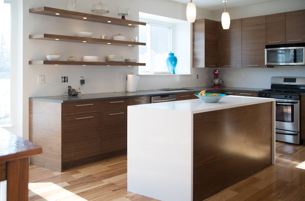 Inspiration for a mid-sized contemporary u-shaped light wood floor kitchen remodel in Detroit with an undermount sink, flat-panel cabinets, dark wood cabinets, quartz countertops, stainless steel appliances and an island