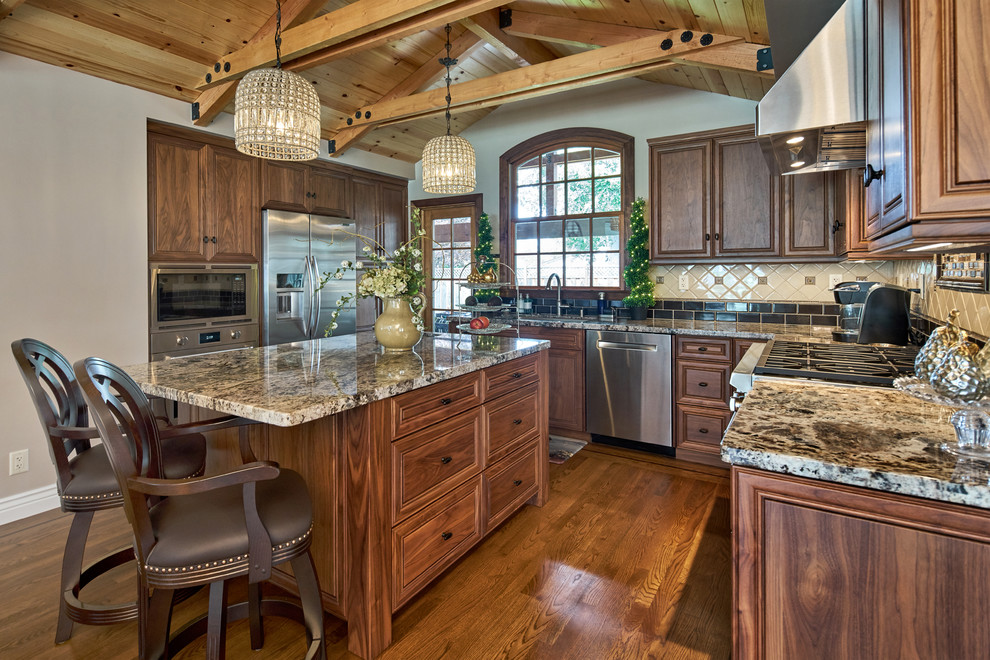 Enclosed kitchen - large traditional u-shaped dark wood floor and brown floor enclosed kitchen idea in San Francisco with an undermount sink, raised-panel cabinets, dark wood cabinets, granite countertops, beige backsplash, ceramic backsplash, stainless steel appliances and an island