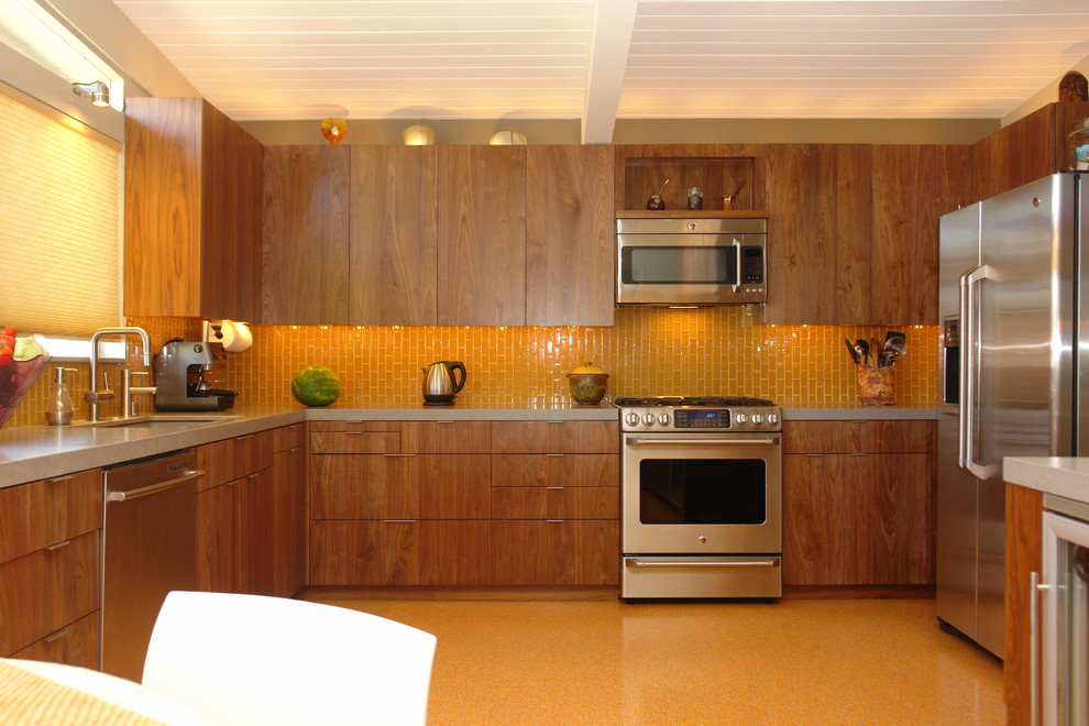 Photo of a large modern u-shaped kitchen/diner in Other with flat-panel cabinets, medium wood cabinets, orange splashback, metro tiled splashback, stainless steel appliances, no island, lino flooring, a submerged sink and engineered stone countertops.