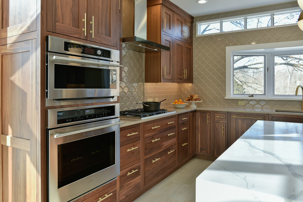 Klassisk inredning av ett stort u-kök, med skåp i shakerstil, skåp i mellenmörkt trä, marmorbänkskiva, grått stänkskydd, rostfria vitvaror, en köksö och en undermonterad diskho