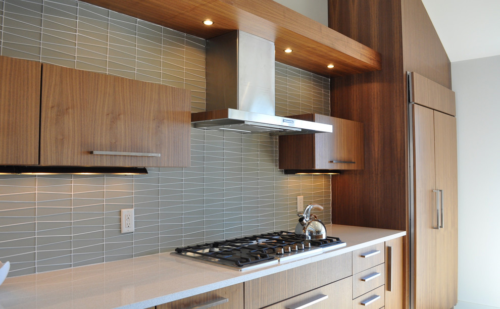 Cette photo montre une cuisine ouverte tendance en L et bois brun avec un placard à porte plane, une crédence grise et îlot.