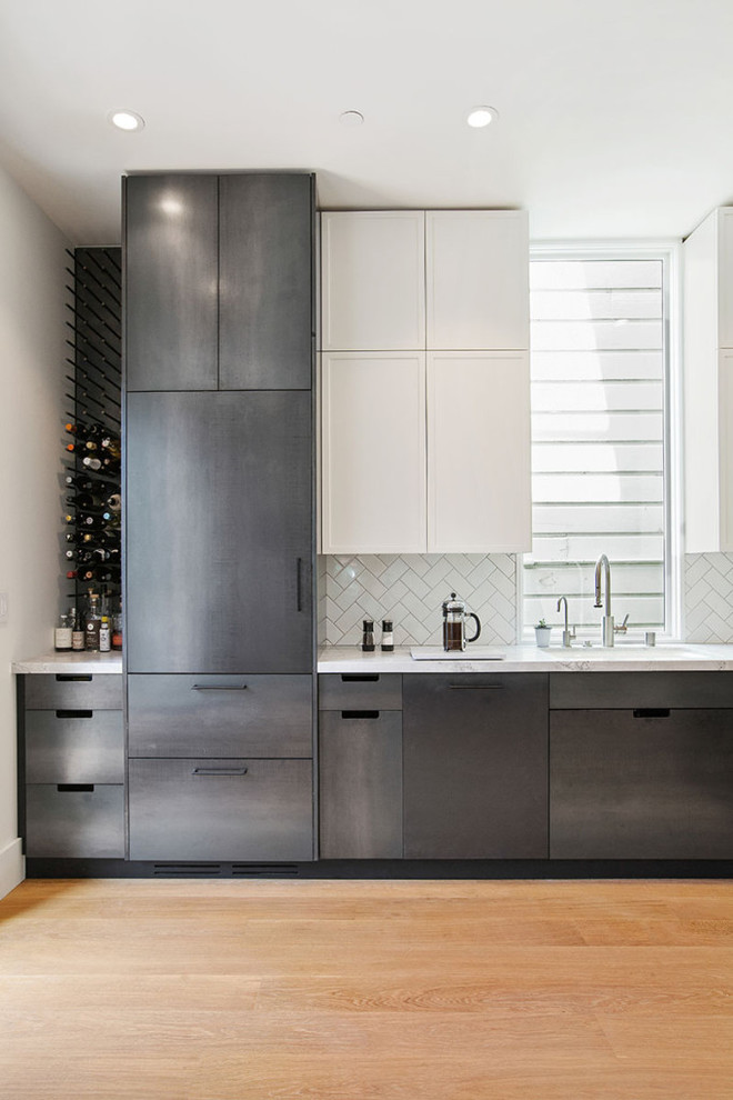 Inspiration for a large modern l-shaped enclosed kitchen in San Francisco with a submerged sink, recessed-panel cabinets, stainless steel cabinets, white splashback, ceramic splashback, stainless steel appliances, light hardwood flooring, no island and quartz worktops.